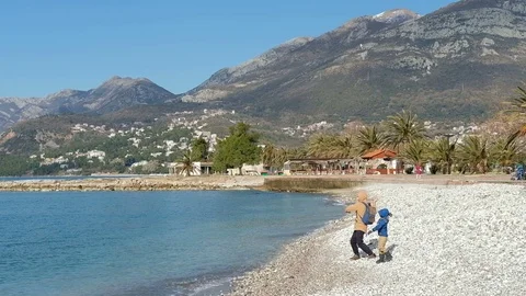 Man teach little child to throw stones into water in very picturesque place Stock Footage 74256407