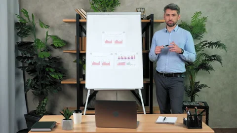 Man teacher teaches students remote videocall points marker diagram on flipchart Video stock 146232772