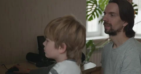 Man Teaches Kid Boy to Play Chess on Computer. 4K 10-bit Stock Footage 320170209