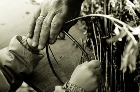Man teaching child making a wicker basket Stock Photos