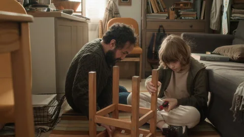 Man Teaching his Young Son How to Build Wooden Chair Video stock 333739873