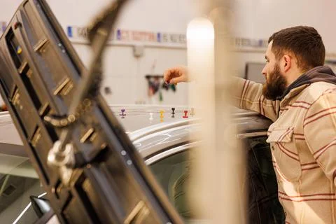 Man technician doing removal of dents without painting in the car service Stock Photos