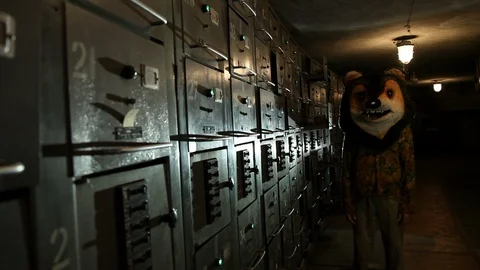 Man with a teddy bear head standing in the basement with electric boxes or Stock Footage 125005635