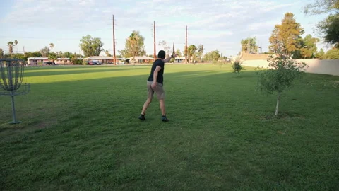A man teeing-off in a game of disk golf Stock Footage 246826367
