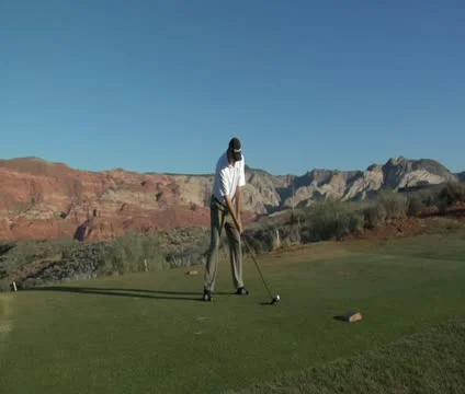 Man tees off on desert golf course Stock Footage 21649091