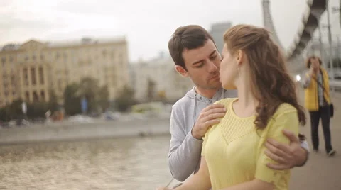 Man tenderly embraces his lover on a bridge Stock Footage 55336663