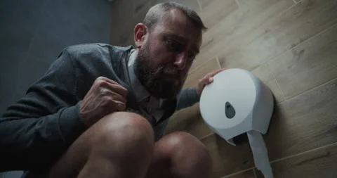 Man with Tense Facial Expression Sitting on Toilet, Suffering from Diarrhea Stock Footage 317548192