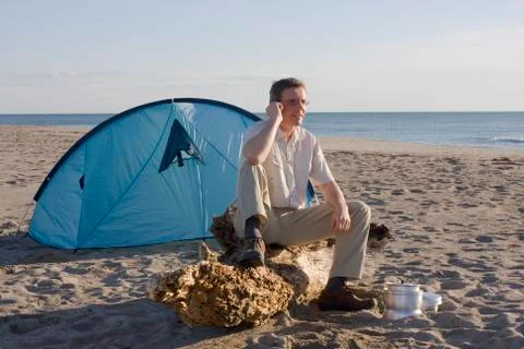 Man with tent on beach Stock Photos