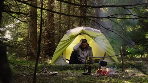 A man in a tent in the forest Stock Footage 144003078