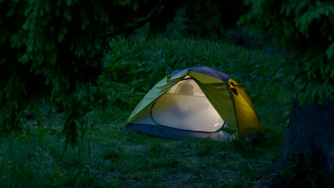 A man in a tent in the night forest Stock Footage 157528428