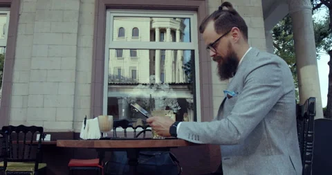 A man on the terrace of a cafe with a tablet in his hand. Stock Footage 139206355