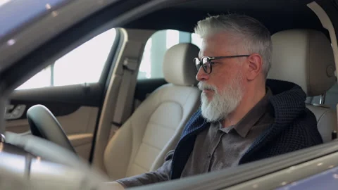 Man testing car and sitting inside during selection at dealership office indoors Stock Footage 158521900