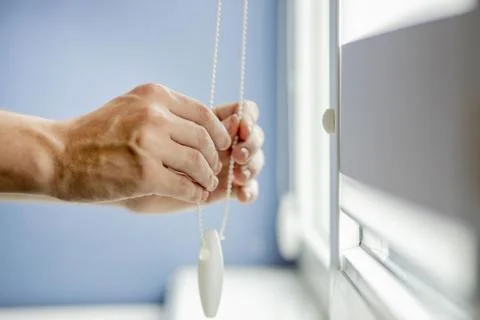 Man testing cassette roller blinds on windows. Stock Photos