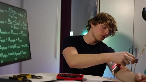 Man testing cybernetic implant while working with neural code in home lab Stock Footage 324443353