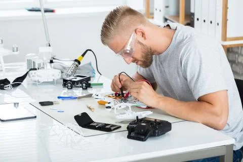 Man Testing Electric Current Of Drone Using Multimeter Tool Stock Photos