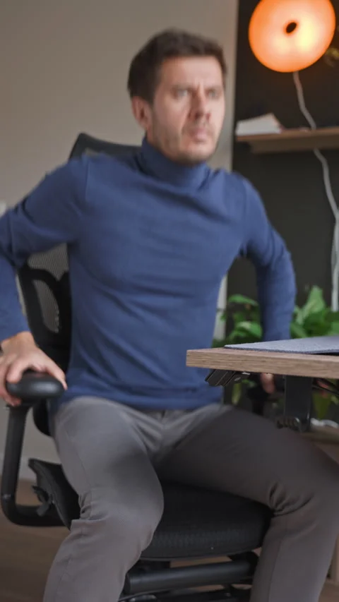 Man testing an ergonomic office chair before work Stock Footage 340490482
