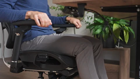 Man testing an ergonomic office chair before work Stock Footage 343318823