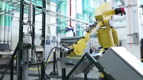 A man tests and programs robotics in a factory setting. Stock Footage