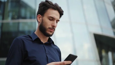 Man text messaging on cellphone and thinking Video stock 113696046