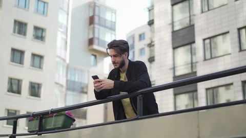 Man texting on cellphone at railing Stock Footage 113696205