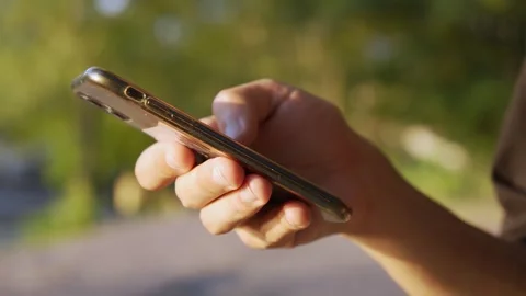 A man is texting on his smartphone in the park Stock Footage 280437324