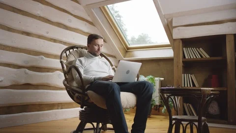Man texting on laptop on the attic Stock Footage 100344715
