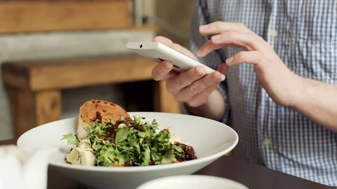 Man texting messages on smartphone during his lunch in the cafe Stock-Footage 72768322