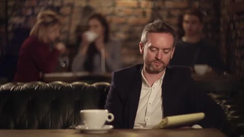 Man texting on notebook and drinking tea in cafe Stock Footage 69942543