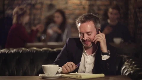 Man texting on notebook and talking on the phone Video stock 69964111