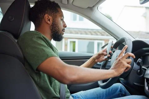 Man Texting Or Using Mobile Phone Whilst Driving Car Stock Photos