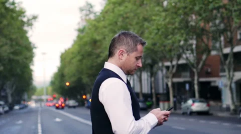 Man texting on smartphone and crossing street, steadycam shot Stock-Footage 44209152