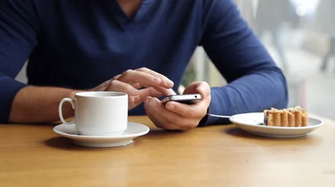 Man texting on smartphone and drinking tea in cafe Stock Footage 67863226