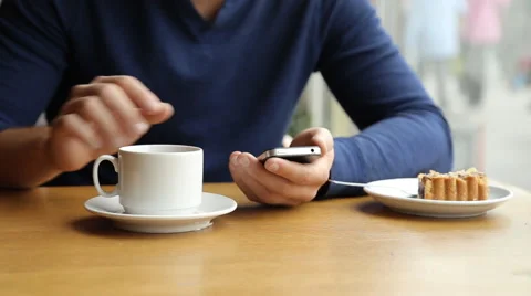 Man texting on smartphone and drinking tea in cafe Stock Footage 67863241
