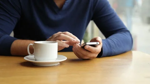 Man texting on smartphone and drinking tea in cafe Stock Footage 67863260