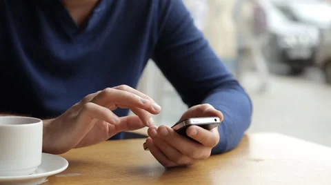 Man texting on smartphone and drinking tea in cafe Stock Footage 67863266