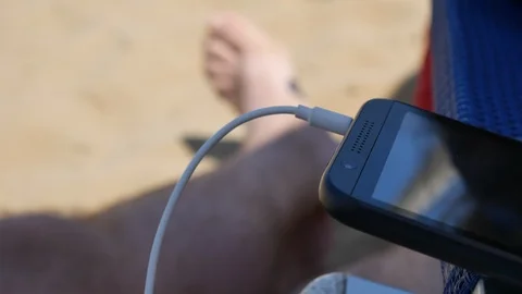 Man texting on smartphone sitting by table in beach restaurant in evening Stock Footage 90316840