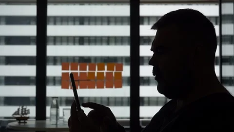 Man texting on smartphone stand by window at room. businessman with  cell phone Stock Footage 239062586