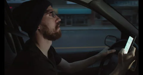 Man Texting while driving in early day light 스톡 동영상 245400415