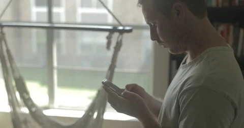 Man texts on smartphone at home Stock Footage 78037901