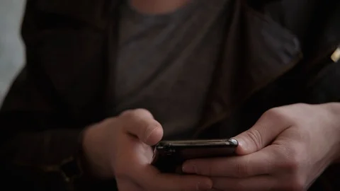 Man with a textured face looks down at mobile phone in hands Video stock 127885547