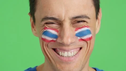 Man with a thai flag painted on the face smiling Stock Footage 255933262