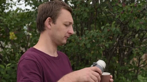 Man with thermos drinking tea outdoors Stock Footage