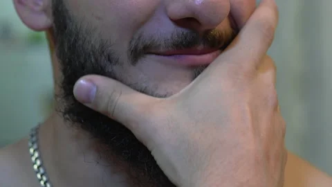 A man with a thick beard, a hand stroking his beard Stock Footage 141145793