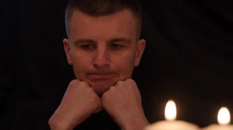 Man  thinking about solutions . Black background with candles Stock Footage 46387605