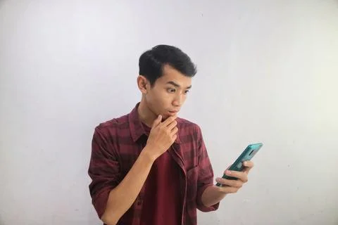 A man thinking about something while looking to his handphone Stock Photos