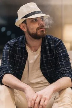 Man thinking about what to do while blowing smoke inside his house. lifestyle Stock Photos