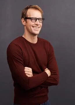 Man, thinking and happy nerd in studio with arms crossed and inspiration on dark 스톡 사진