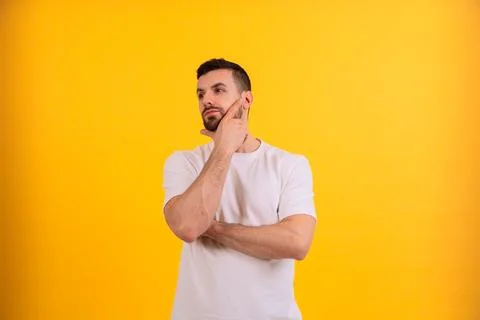 Man thinking and looking up against yellow background.Copy space Stock Photos