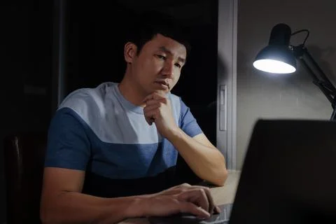 Man thinking and working with laptop at night Stock Photos