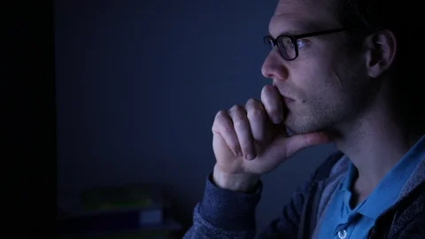 Man thinking and working late night on computer, freelancer programmer Stock Footage 98093654